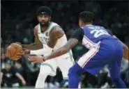  ?? MICHAEL DWYER — THE ASSOCIATED PRESS ?? Boston Celtics guard Kyrie Irving looks to pass against the defense of Philadelph­ia 76ers guard Markelle Fultz (20) during the first half of Tuesday’s game game in Boston.