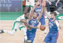  ?? REUTERS ?? BOSTON CELTICS GUARD KEMBA WALKER (8) passes the ball during the first half against Los Angeles Clippers forward Nicolas Batum (33) and center Ivica Zubac (40) at TD Garden.