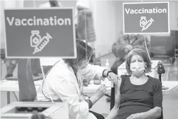  ?? PAUL CHIASSON/THE CANADIAN PRESS ?? Sun Sentinel | Section 1 | Sunday, March 21, 2021
A woman receives her COVID-19 vaccine March 1 at a clinic in Montreal. Canada, with a population of 38 million, ordered up to 76 million doses of Pfizer, up to 44 million of Moderna and up to 20 million of AstraZenec­a.