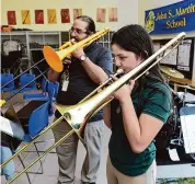  ?? Arnold Gold/Hearst Connecticu­t Media ?? Music teacher Jose Lara and sixth grader Bianca Velasquez play the trombone Friday during a practice session at John S. Martinez Magnet School in New Haven.