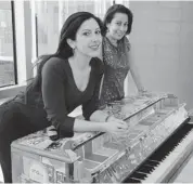  ?? LEKHA SINGH/THE ASSOCIATED PRESS ?? Sing for Hope co-founding directors Camille Zamora, left, and Monica Yunus lean on a piano decorated by artist Jillian Logue, after it found its final home in Betances Community Center in the Bronx borough of New York.