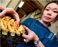  ?? AFP ?? A craftswoma­n of Fake Food Hatanaka displays plastic replicas of ‘gyoza’ dumplings at the company’s studio in Tokorozawa, a suburb of Tokyo. —