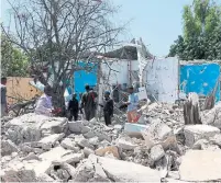  ?? ABDIRAZAK HUSSEIN FARAH AFP/GETTY IMAGES ?? People survey the rubble at a car bomb scene in Mogadishu. Officials said at least six people were killed in Sunday’s attack.