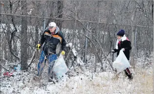  ??  ?? Tom and Riona Reed clean up garbage in the Cook County Forest Preserves near the Sand Ridge Nature Center in South Holland.