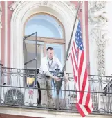  ??  ?? A consulate employee lifts up the US flag at the US consulate in St.Petersburg, Russia, Saturday, March 31, 2018. The flag was flown at half-mast to mourn victims of Kemerovo fire killing 64 people. (AP)