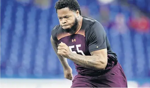  ?? MICHAEL CONROY/AP ?? Florida offensive lineman Jawaan Taylor runs a drill at the NFL football scouting combine in Indianapol­is on March 1. Taylor is a potential first-round pick in the NFL draft.