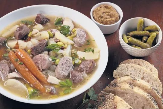  ?? ABEL URIBE/CHICAGO TRIBUNE PHOTOS; SHANNON KINSELLA/FOOD STYLING ?? Serve pot au feu in two courses as they do in France. First, a cup of the rich broth with a chunk of good bread. Then, a platter of the cooked meats and vegetables to enjoy with condiments.