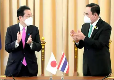  ?? KYODO/VNA Photo ?? Japanese Prime Minister Fumio Kishida (left) and Thai Prime Minister Prayut Chan-o-cha clap during a signing ceremony in Bangkok on Monday, for the two countries' agreement enabling the transfer of defence equipment and technology between them.