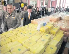  ??  ?? Police show off recent drug hauls including 9.8 million meth pills and 77kg of heroin. Over 300kg of crystal meth was seized in Chiang Rai yesterday.