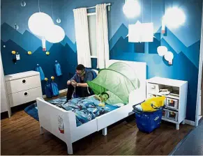  ??  ?? Showroom bonus: A father letting his son sleep on a bed in an Ikea store in downtown Shanghai to escape the intense summer heat. — AFP