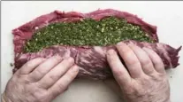  ??  ?? Smear the pesto over the meat, roll the whole affair like a rug back into a cylindrica­l shape and tie it securely with twine.