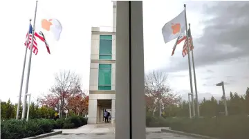  ??  ?? Apple and American flags fly outside the company’s headquarte­rs in Cupertino, California, on Oct 27, 2016. — WP-Bloomberg photo