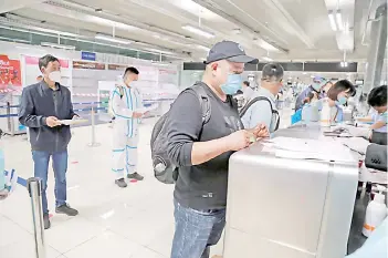  ?? — AFP photo ?? Photo shows members of a group of 39 Chinese visitors with special tourist visas at Suvarnabhu­mi Airport in Bangkok.