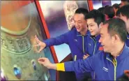  ?? ZOUHONG / CHINA DAILY ?? National table tennis team members view the Digital Palace Museum display at the Five Years of Sheer endeavor exhibition at the Beijing exhibition hall on Monday