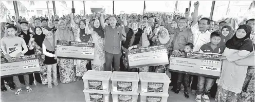  ??  ?? JAILANI (lapan, kiri) bergambar bersama penerima sumbangan pada Program NBOS-CTU Menghubung Menyatu Parlimen Hulu Terengganu di Kampung Landas Ajil, pada Sabtu. -Gambar Bernama