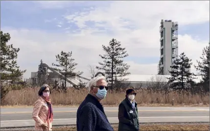  ??  ?? Clean Air Coalition of Greater Ravena and Coeymans members Christine Primomo, left, Ray Kottke and Barbara Heinzen stand within view of the Lafargehol­cim cement plant on Route 9W in Ravena.