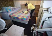  ?? (AP Photo/Andre Penner) ?? Karina Valdo changes her son’s diaper inside her shack in the Jardim Julieta squatter camp Thursday in Sao Paulo, Brazil.