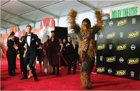  ?? PHoto/FReDeRiC J. BRoWn
Foto: LeHtiKuva/aFP ?? Joonas Suotamo till vänster, fan iförd Chewbacca-kostym till höger, på premiären av Solo: A Star Wars Story i Hollywood förra veckan.