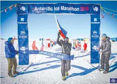  ?? CONTRIBUTE­D PHOTO ?? Doc Yong proudly waves the Philippine flag at the finish line of the 2019 Antarctic Ice Marathon in Union Glacier, Antarctic where he completed his epic eight-continent marathon journey.