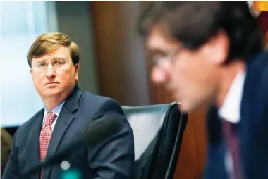  ??  ?? Mississipp­i Gov. Tate Reeves, left, listens as State Health Officer Dr. Thomas Dobbs, discusses the state’s efforts to reduce and limit transmissi­on from the COVID-19 virus, Monday, July 20, 2020, during a press briefing in Jackson, Miss. (AP Photo/rogelio V. Solis)