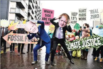  ?? AFP ?? Climate activists wear the masks of US President Joe Biden (left) and UK Prime Minister Boris Johnson at an anti-fossil fuel protest in Glasgow in November during the COP26 UN Climate Change Conference.