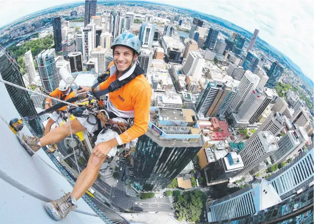  ??  ?? GREAT HEIGHTS: Abseil painters Matt Hulme, 24, and Lionel Taylor, 30, both of New Farm, painting the 250m-high Riparian Plaza in Brisbane. Picture: LIAM KIDSTON