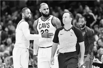  ??  ?? Cleveland Cavaliers forward LeBron James (second left) reacts with Dwyane Wade (left) after he was ejected by referee Kane Fitzgerald in the third quarter against the Miami Heat at Quicken Loans Arena. — USA TODAY Sports photo