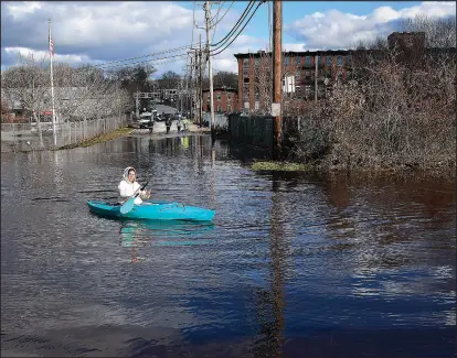  ?? Photo by Ernest A. Brown ?? Savannah Joseph, manager of the Hotel for Homeless Dogs in Cumberland, heads back to the shelter to evacuate more dogs as the Blackstone River overflowed its banks, flooding homes and business along Martin Street in Cumberland Tuesday.