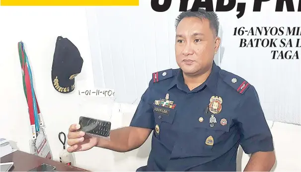  ?? / ARNOLD Y. BUSTAMANTE ?? EBIDENSYA: Si Chief Inspector Leo Dofiles, hepe sa Anti Cyber Crime Group (ACG) 7 mipakita sa usa ka cell phone nga ebidensya nga ilang nakuha sa lalakeng gireklamo sa iyang 16-anyos nga uyab. Naa sa cell phone ang giingon nga video diin ang dalaga...