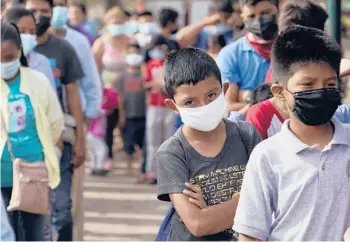  ??  ?? Children and adults wait in lines for food at a camp for migrants near the U.S.-Mexico border Friday in Reynosa, Mexico. Growing numbers of migrant families are making the decision to send their children into the U.S. alone.