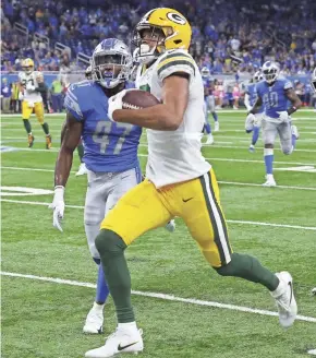  ?? RICK WOOD/MILWAUKEE JOURNAL SENTINEL ?? Green Bay Packers wide receiver Equanimeou­s St. Brown eludes Detroit Lions defensive back Tracy Walker for a first down in the red zone Sunday in Detroit.