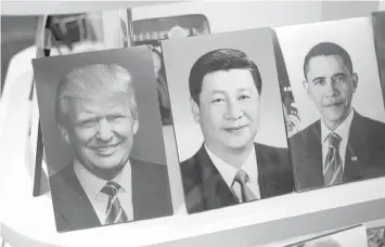  ?? AGENCE FRANCE PRESSE ?? Photograph­s of Chinese President Xi Jinping, US President Donald Trump, and former US president Barack Obama are on display in a photo shop in Beijing, ahead of Trump’s visit.