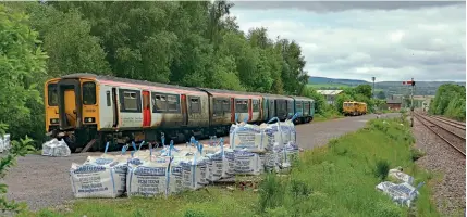  ?? ?? Class 150 units Nos. 150242 and 150279 await recovery by road transport at a siding near Craven Arms on May 28. Keith Boddey