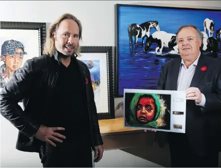  ?? LEAH HENNEL ?? Paul Van Ginkel looks on as Patrick Ward of Painted Pony displays Van Ginkel’s art on the cover of this year’s HOPEthiopi­a calendar.