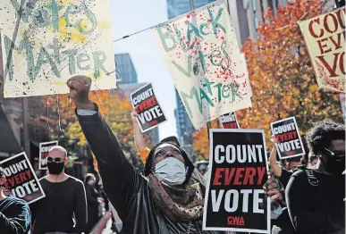  ?? REBECCA BLACKWELL THE ASSOCIATED PRESS ?? Zhanon Morales, 30, raises her fist as demonstrat­ors call for all votes be counted during a rally in Philadelph­ia Thursday.