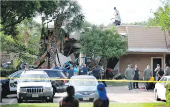  ??  ?? Authoritie­s investigat­e the scene of a helicopter crash at an apartment complex in Houston, Texas, on Saturday. The cause of the crash wasn’t immediatel­y known.