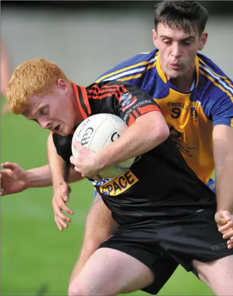  ??  ?? Darren McMahon, St. Mochta’s tries to get to grips with James Carragher of Mattock Rangers during their IFC quarter-final clash.