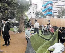  ?? AMIR LEVY/GETTY ?? Ultra-Orthodox Jews build an outdoor synagogue Thursday in Bnei Brak, Israel, ahead of a three-week coronaviru­s lockdown. The second nationwide lockdown begins Friday.