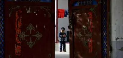  ?? Andy Wong/Associated Press ?? A Uighur child plays alone in the courtyard of a home at the Unity New Village in Hotan, in western China’s Xinjiang region.