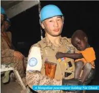  ??  ?? A Mongolian peacekeepe­r holding Nia Ghaak