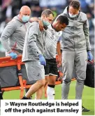  ??  ?? > Wayne Routledge is helped off the pitch against Barnsley
