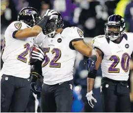  ?? JARED WICKERHAM/GETTY IMAGES ?? Cary Williams, left, of the Baltimore Ravens celebrates with Ray Lewis, centre, after intercepti­ng a pass against the New England Patriots in the AFC championsh­ip game.