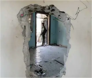  ?? — AFP ?? A member of the Syrian Democratic Forces holds a position inside a damaged building in Raqa as they battle to retake the northern Syrian city from the IS group.