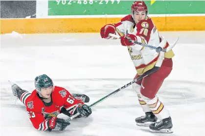  ?? TIM KROCHAK ■ THE CHRONICLE HERALD ?? Halifax Mooseheads Jake Todd and Acadie-bathurst Titan Cory Macgillivr­ay battle for a flying puck during QMJHL action in Halifax on Thursday.