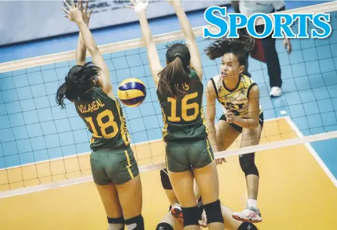  ?? ABS-CBN SPORTS ?? A fiery Cherry Rondina (rightmost) of the University of Santo Tomas Golden Tigresses hits past the defensive of the Far Eastern University Lady Tamaraws in the UAAP Season 79 women’s volleyball tournament.