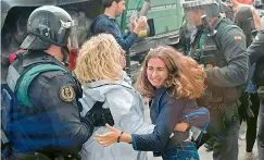  ?? AFP ?? Women clash with Spanish Guardia Civil guards outside a polling station in Sarria de Ter on Sunday. —