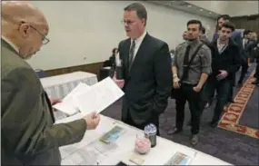  ?? M. SPENCER GREEN — THE ASSOCIATED PRESS FILE ?? Ralph Logan, general manager of Microtrain, left, speaks with James Smith who is seeking employment during a National Career Fairs job fair in Chicago. U.S. employers notched another solid month of hiring in March by adding 215,000jobs, driven by large...