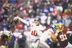  ?? Nick Wass / Associated Press ?? Giants quarterbac­k Eli Manning throws during the second half Sunday in Landover, Md. Manning threw three touchdown passes before rookie Kyle Lauletta replaced him.