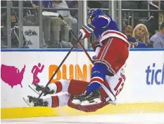  ?? BRUCE BENNETT/GETTY IMAGES ?? Hurricanes' Max Domi is checked by Rangers' Jacob Trouba during the first period at Madison Square Garden on Tuesday in New York City.