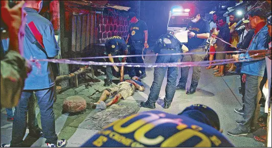  ?? JOVEN CAGANDE ?? Police probers gather evidence near the body of an alleged drug peddler known only as Bong who was killed in a sting in Quezon City on Tuesday.